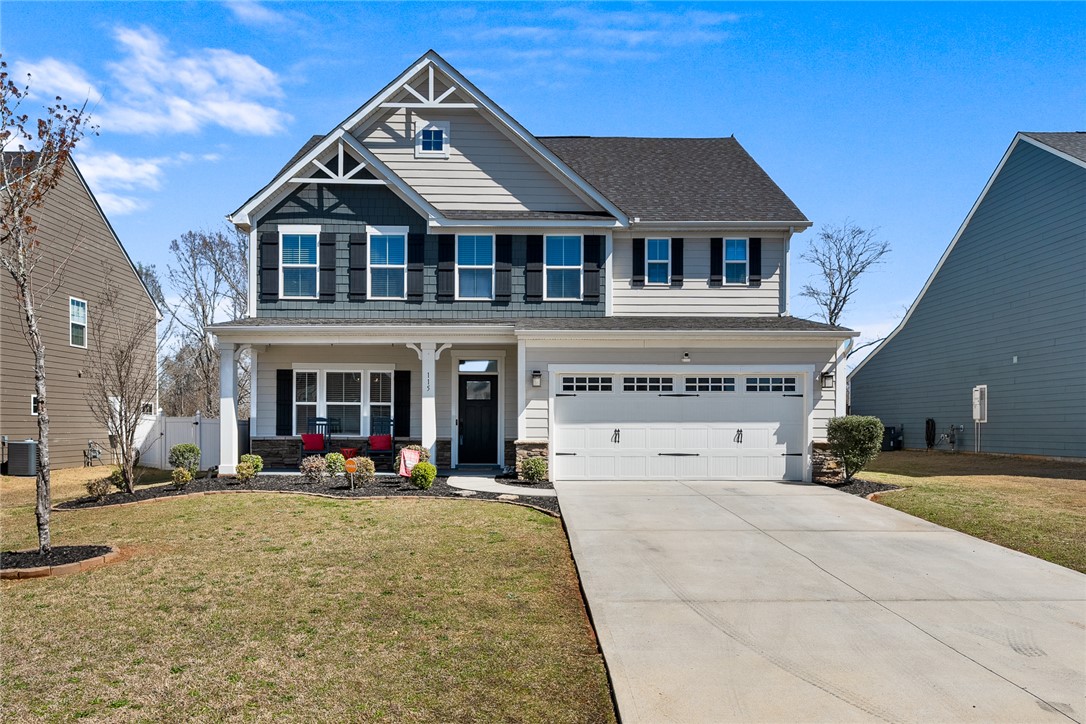This inviting home presents a classic facade with a welcoming front porch and ample driveway space.