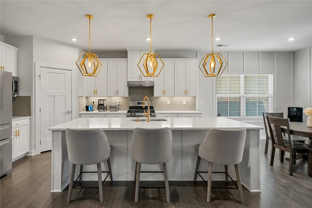 115 Bronson Ridge Anderson, SC 29621 - Photo 14 of 42 This modern kitchen features a spacious island, elegant lighting, and ample cabinetry for culinary enthusiasts.