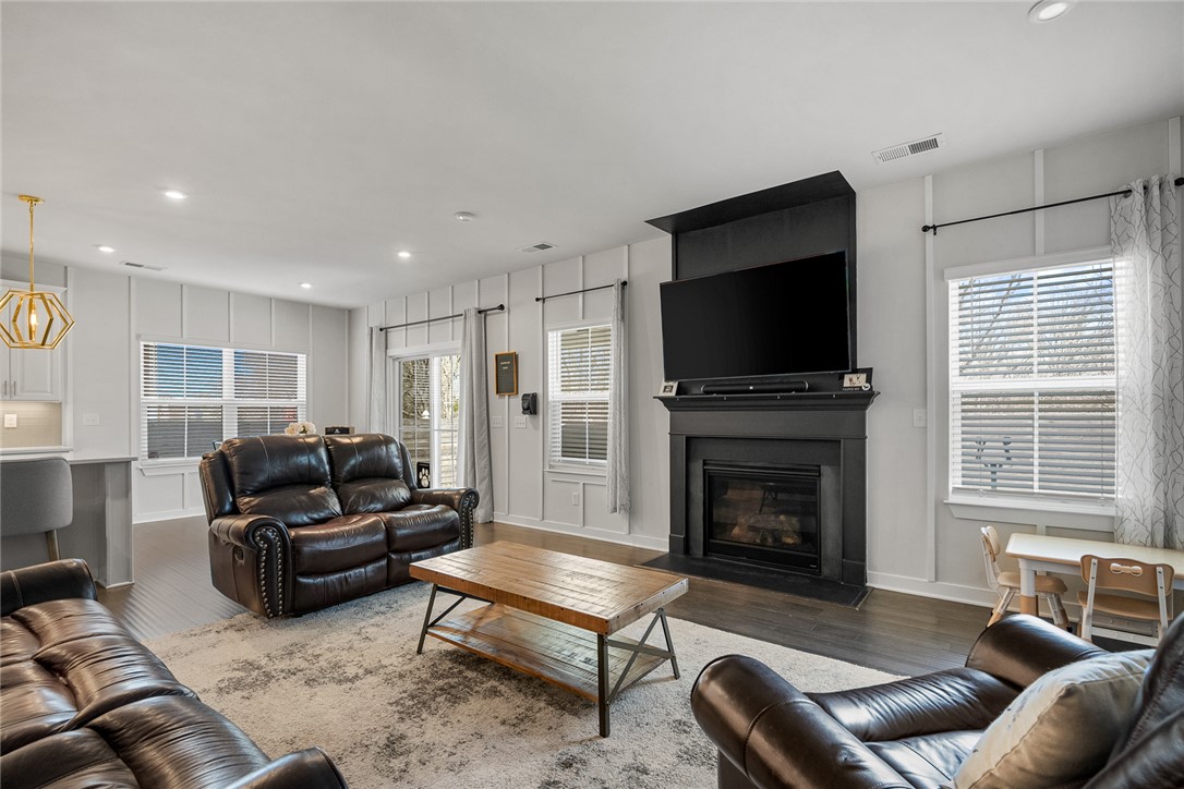 115 Bronson Ridge Anderson, SC 29621 - Photo 10 of 42 A well-lit living area features hardwood floors and a cozy fireplace, perfect for gatherings.