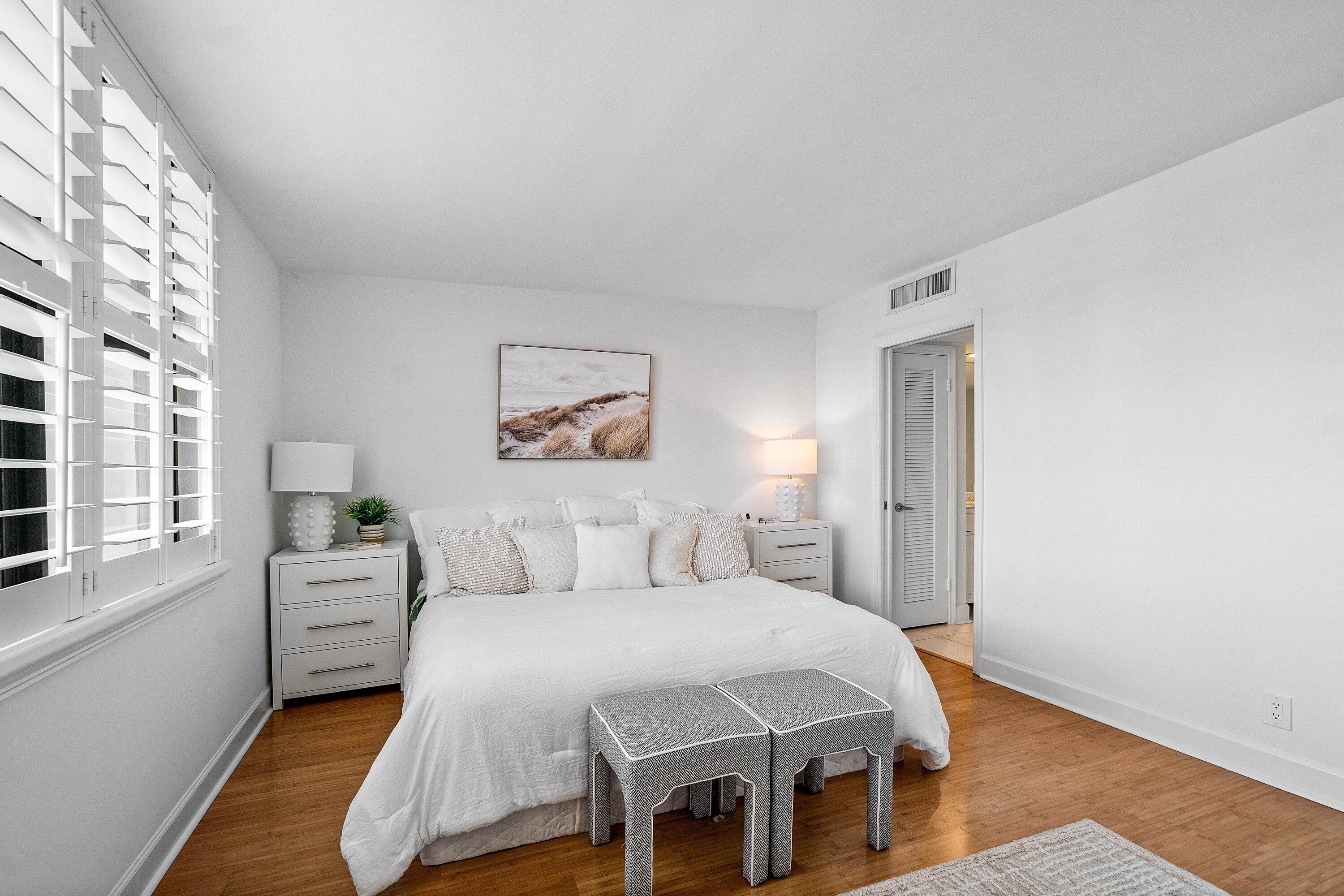 3800 Washington Road, Unit 904 West Palm Beach, FL 33405 - Photo 12 of 27 a bedroom with a large bed and a chandelier