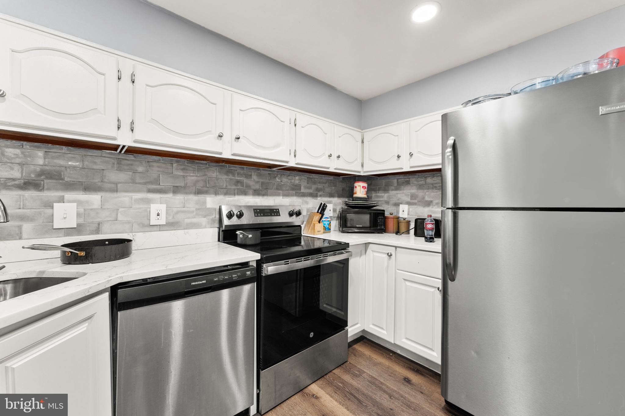8146 Gray Haven Road Dundalk, MD 21222 - Photo 11 of 18 a kitchen with stainless steel appliances granite countertop white cabinets sink and refrigerator
