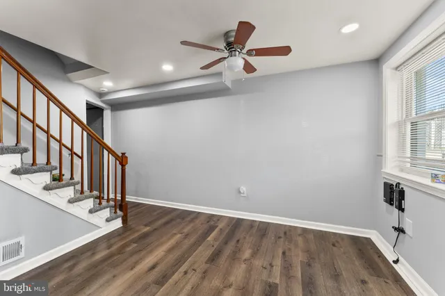 a view of staircase with lots of frames on wall and wooden floor