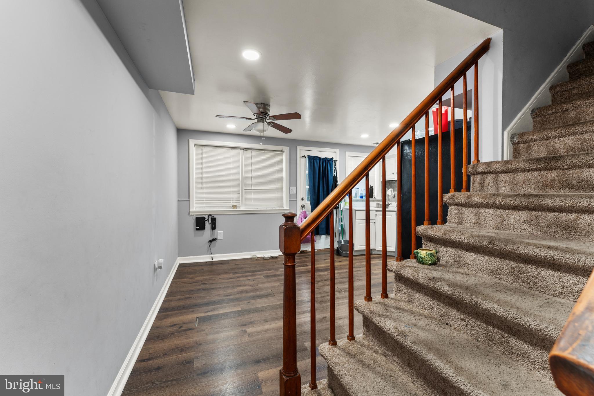 8146 Gray Haven Road Dundalk, MD 21222 - Photo 10 of 18 a view of staircase with lots of frames on wall and wooden floor