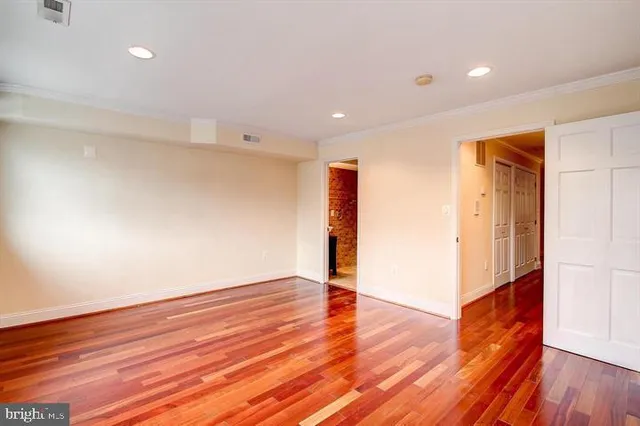 a view of empty room with wooden floor