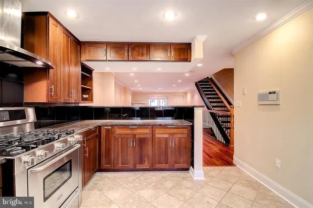 a kitchen with stainless steel appliances granite countertop a stove a sink and a microwave