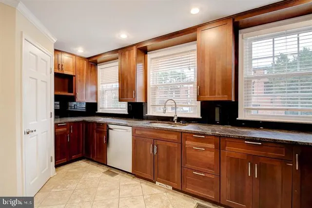 a large kitchen with granite countertop a sink and a window