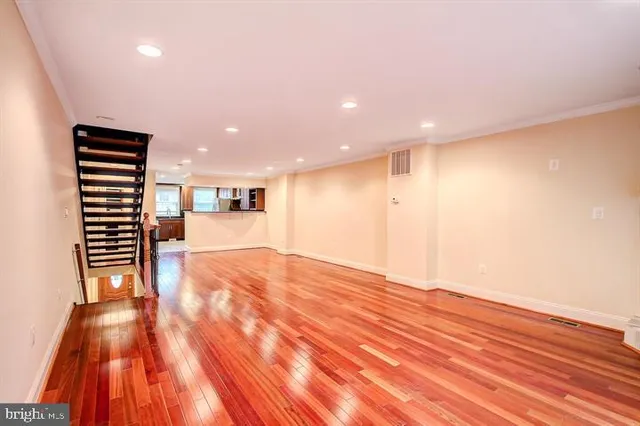 a view of empty room with wooden floor and windows