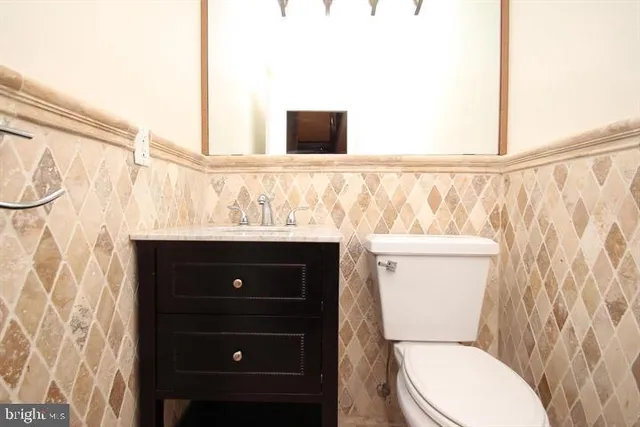 a bathroom with a toilet a sink and a mirror