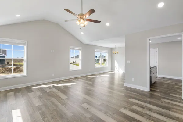 an empty room with wooden floor and window