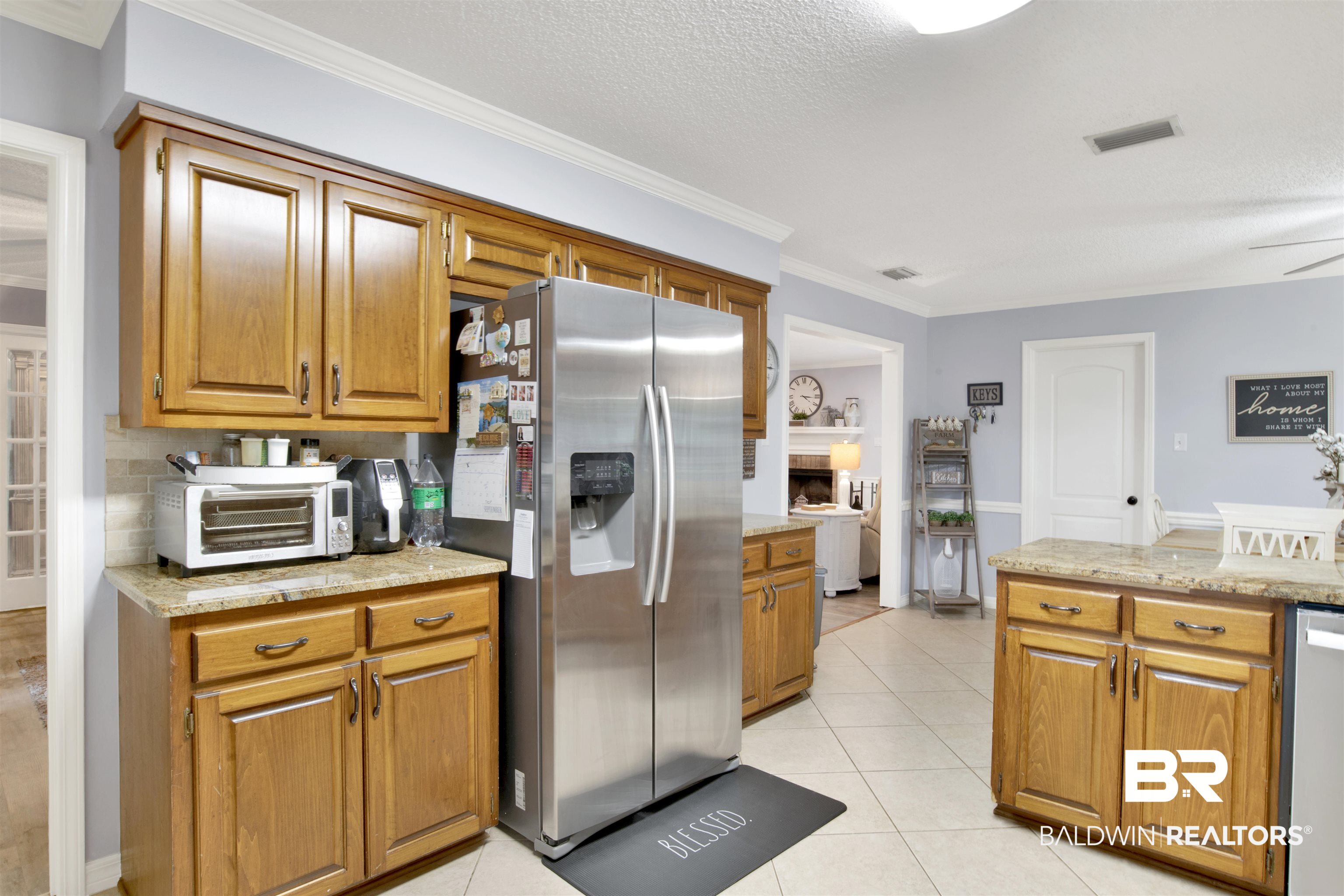 13385 Tom Gaston Road Mobile, AL 36695 - Photo 10 of 42 Kitchen featuring ceiling fan, light tile patterned flooring, a textured ceiling, appliances with stainless steel finishes, and crown molding