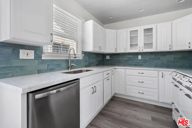 a kitchen with granite countertop white cabinets and sink