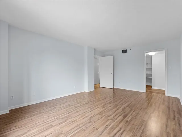 a view of an empty room with wooden floor