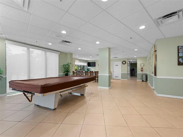 a room with pool table and windows