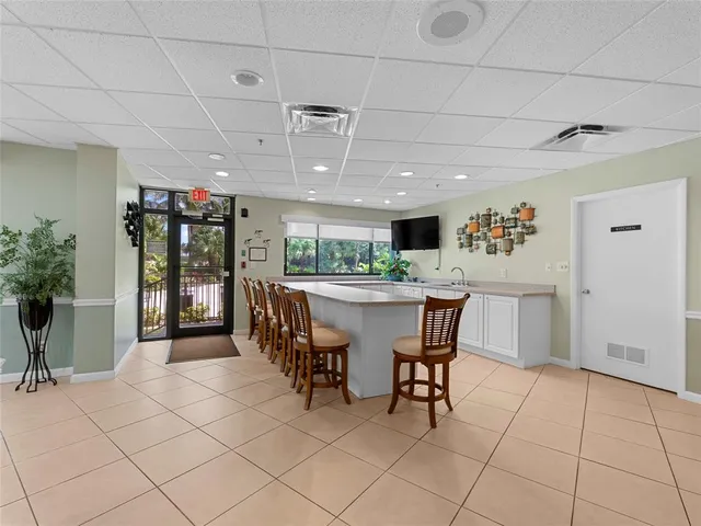 a kitchen with stainless steel appliances kitchen island granite countertop a table chairs and a refrigerator