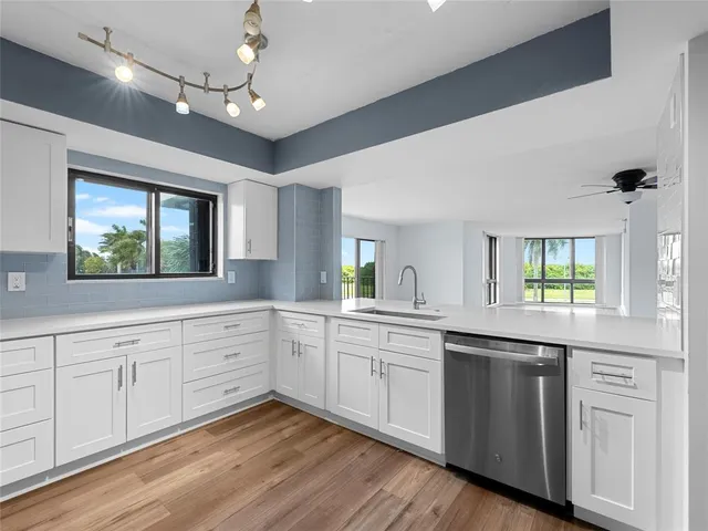 a kitchen with white cabinets and sink