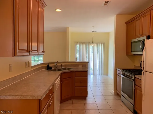 a kitchen with a sink a stove cabinets and stainless steel appliances