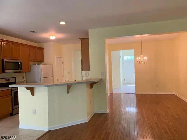 a view of a kitchen with stainless steel appliances cabinets and a wooden floor