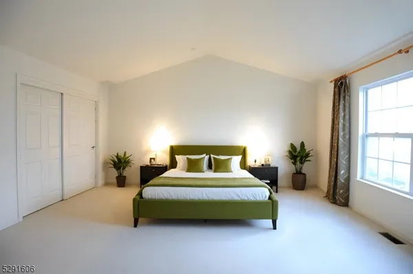 a bedroom with a bed lamp and a large window