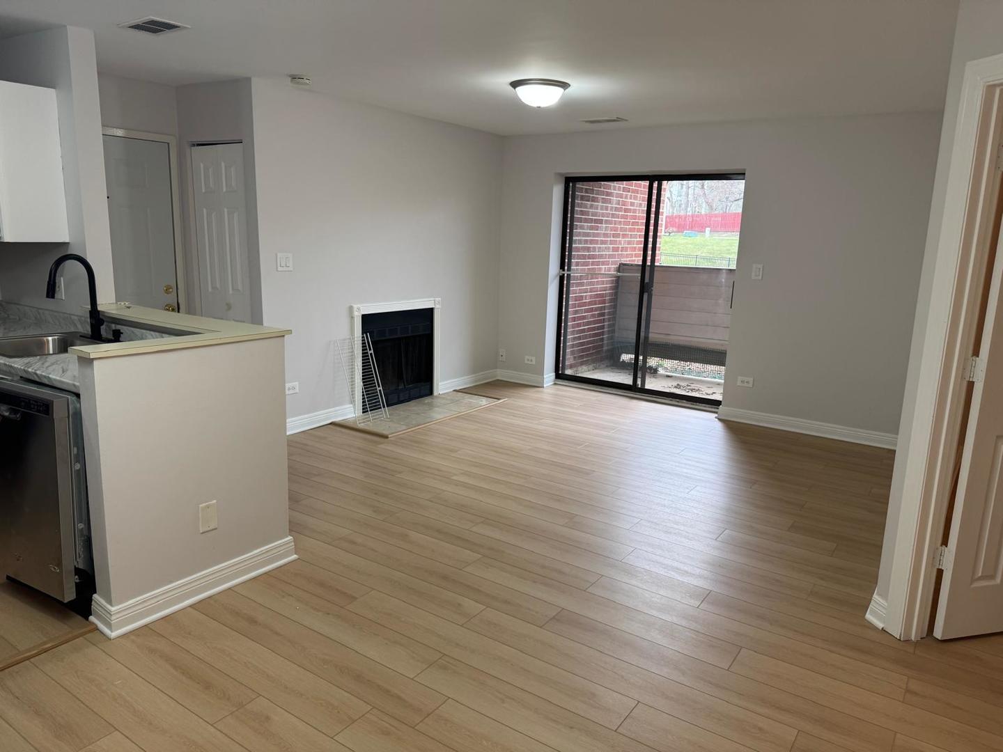 1935 North Hicks Road, Unit 106 Palatine, IL 60074 - Photo 8 of 16 an empty room with wooden floor and windows