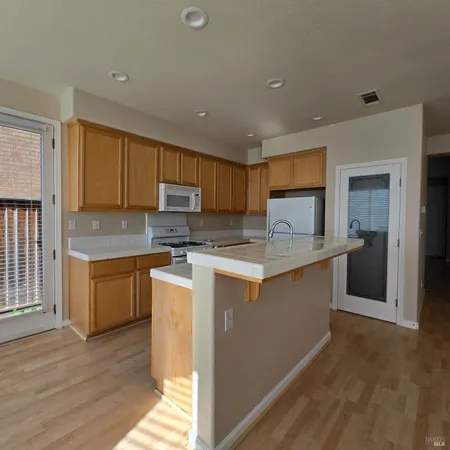 a kitchen with granite countertop a refrigerator stove top oven and sink