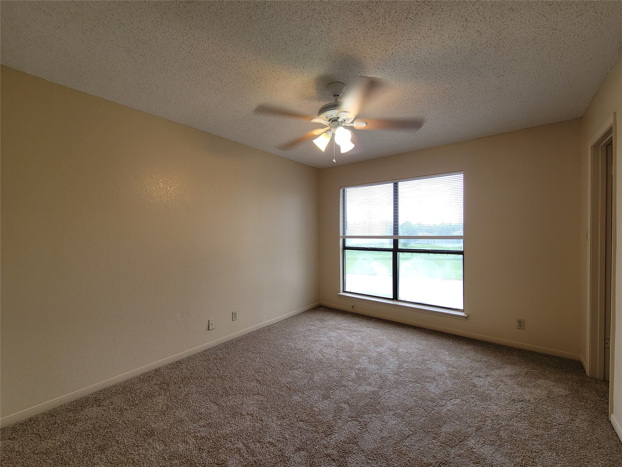 2804 Bull Run, Unit B Taylor, TX 76574 - Photo 8 of 9 an empty room with chandelier fan and windows
