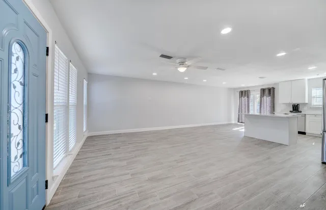 a view of a big room with wooden floor and windows