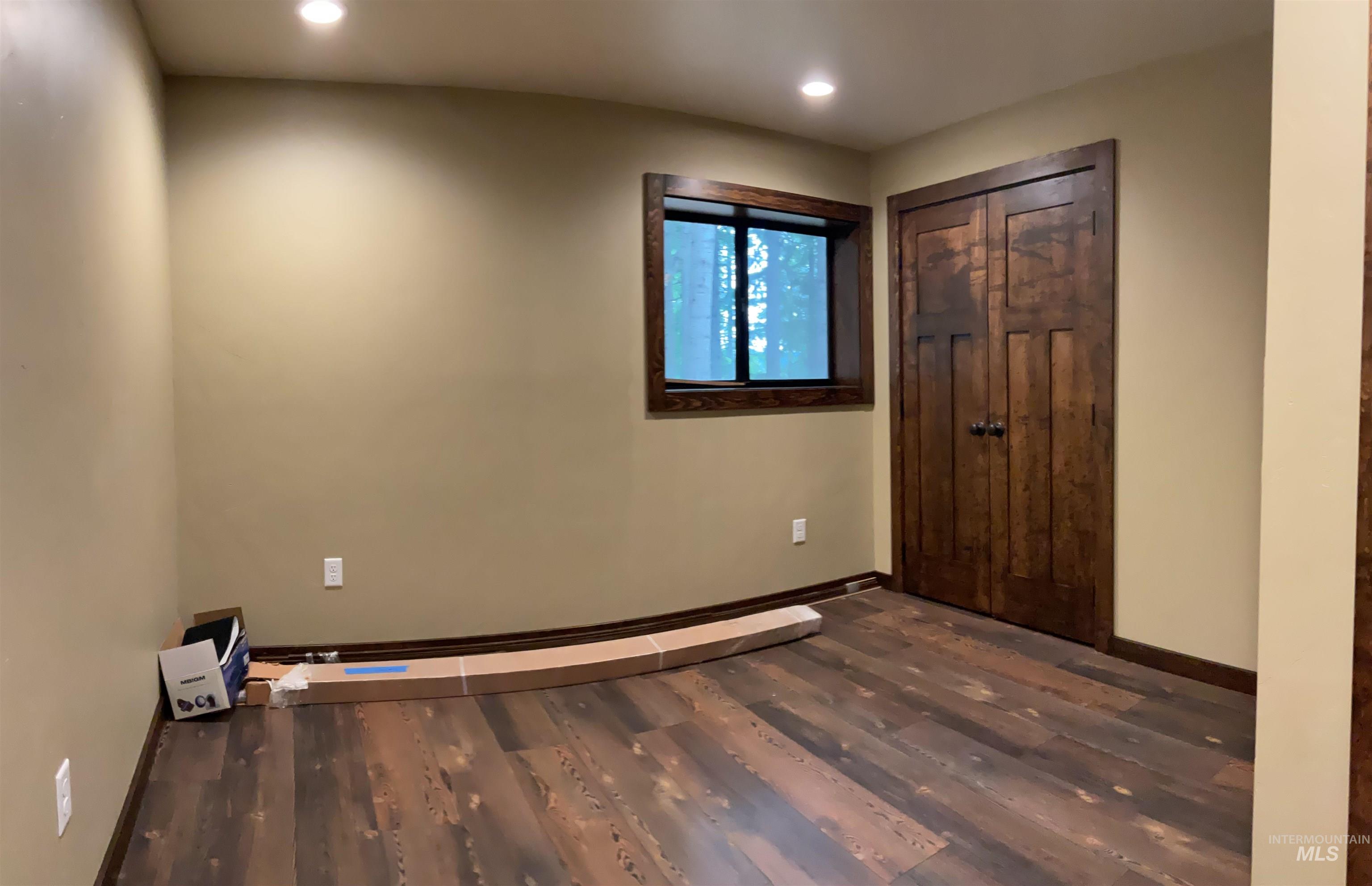 6125 Freeman Creek Road Lenore, ID 83541 - Photo 37 of 44 Room featuring wood-finish flooring, light tan walls, and two paneled wood doors with matching wood trim