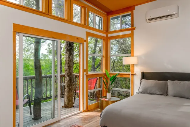 a bedroom with a bed and a large window with outer view