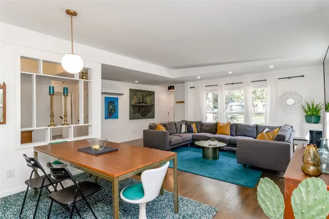 a living room with furniture a chandelier and a table