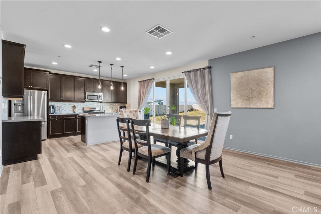 6949 Beale Road Palmdale, CA 93552 - Photo 5 of 32 a view of a dining room with furniture and wooden floor