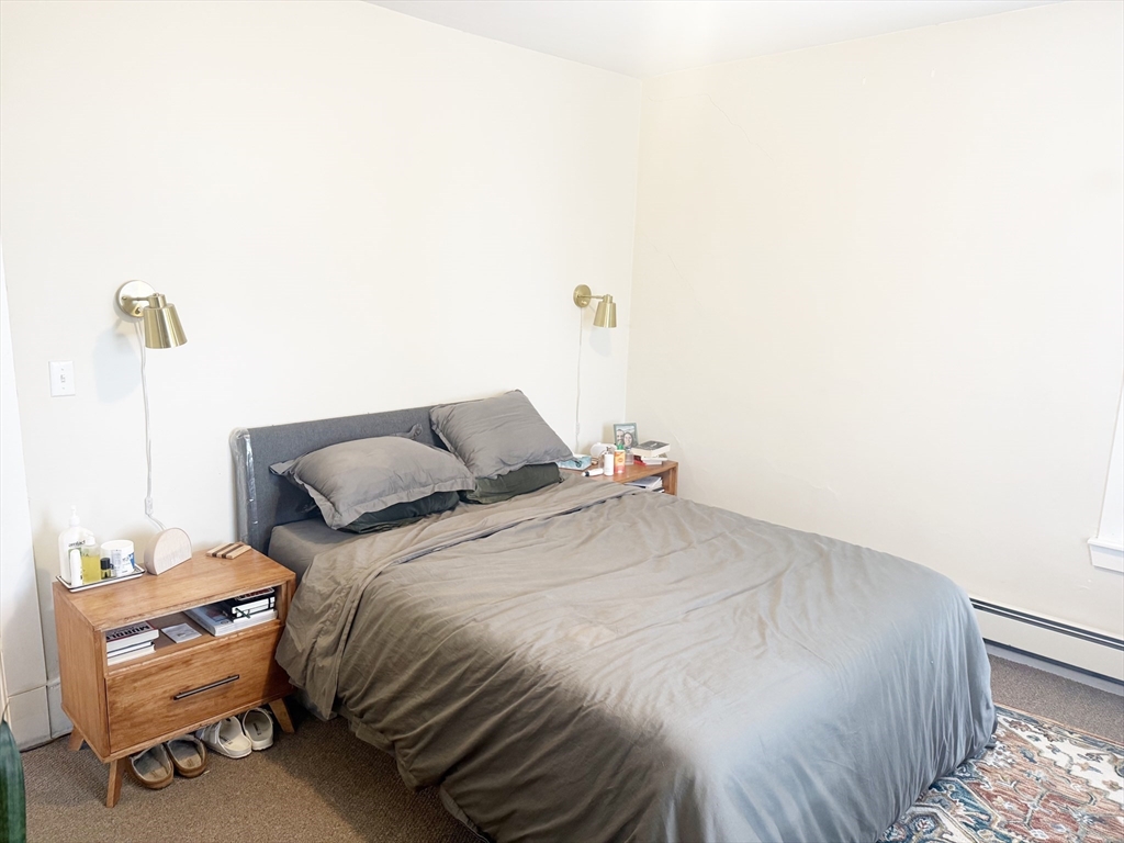 37 Prospect St Avenue, Unit 2 Waltham, MA 02453 - Photo 4 of 14 a bedroom with a bed and a mirror