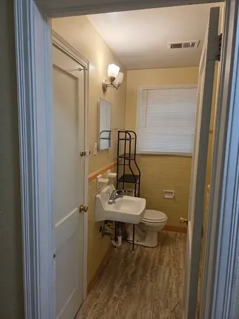 a bathroom with a toilet a sink and mirror