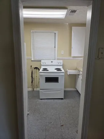 a utility room with a stove a washer and dryer