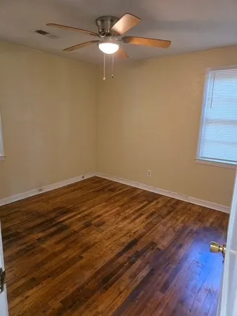a view of a room with wooden floor closet and ceiling fan