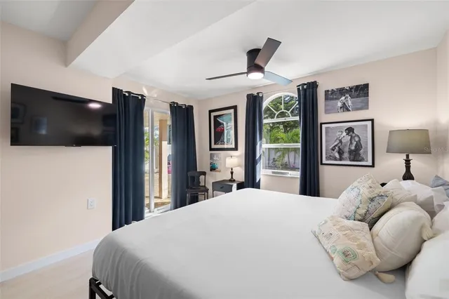 a bedroom with a bed window and a flat screen tv