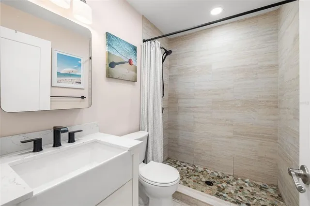 a bathroom with a sink toilet and shower