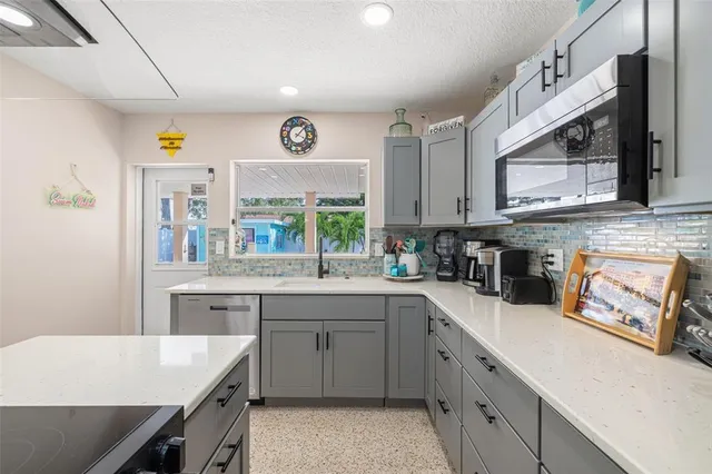 a kitchen with a sink a stove a microwave and cabinets