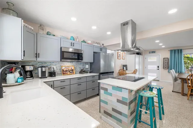a kitchen with stainless steel appliances kitchen island granite countertop a stove and a sink