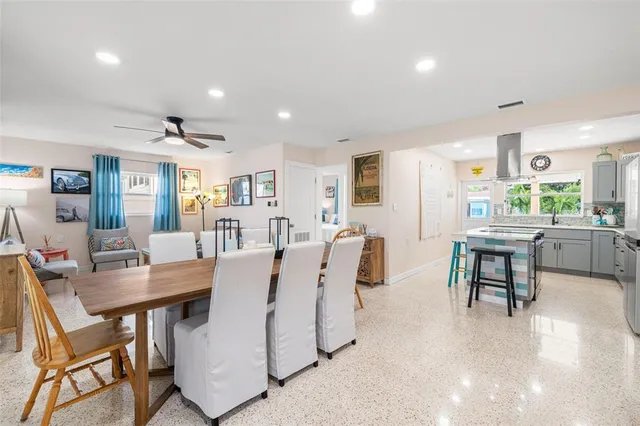 a living room with furniture a dining table and chairs with kitchen appliances