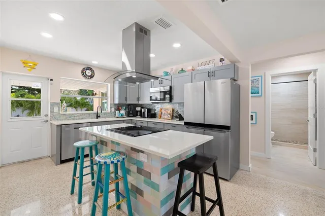a kitchen with a table chairs refrigerator and cabinets