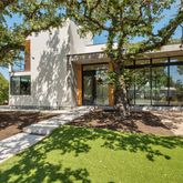 a front view of a house with a tree in a yard