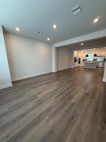 a large kitchen with stainless steel appliances a large counter top a sink a stove and a refrigerator