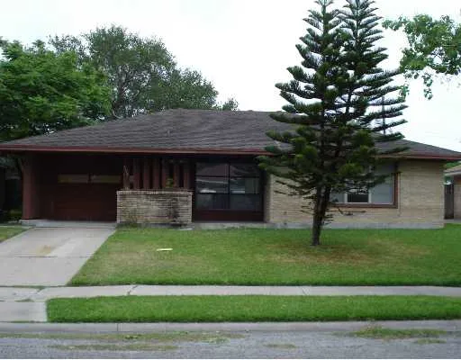 a front view of a house with a garden and trees