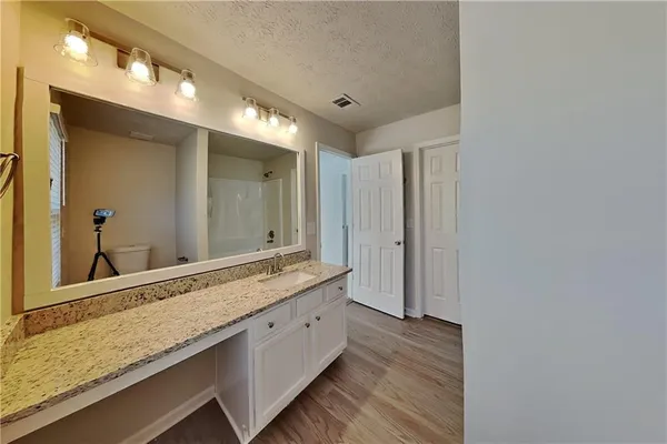 a bathroom with a granite countertop sink and a mirror