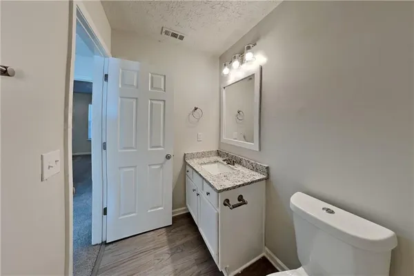 a bathroom with a toilet a sink and mirror