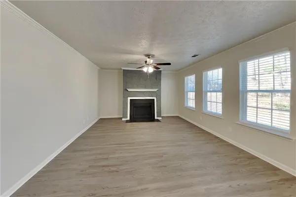 a view of an empty room with a fireplace and a window