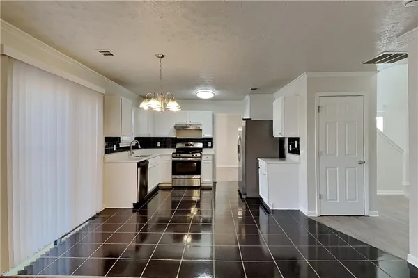 a kitchen with stainless steel appliances a refrigerator sink and cabinets