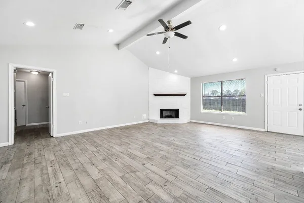a view of an empty room with a window and fireplace
