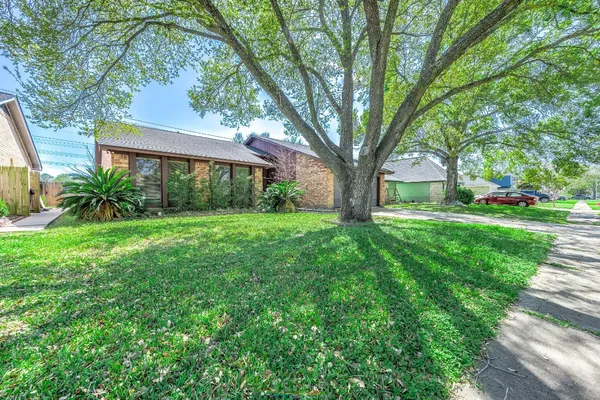 a view of a yard in front of a house with large tree