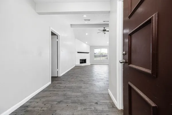 a view of a hallway to a bedroom and front door